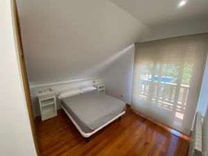 Łóżko lub łóżka w pokoju w obiekcie Duplex en Sanxenxo con piscina y vistas al mar