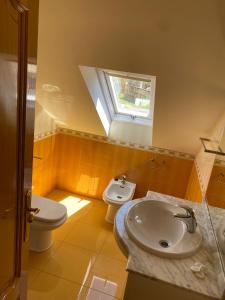 łazienka z umywalką, toaletą i oknem w obiekcie Duplex en Sanxenxo con piscina y vistas al mar w mieście Sanxenxo