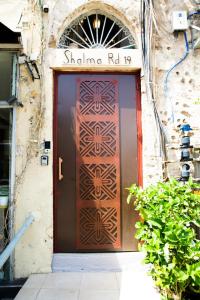 Una puerta a un edificio con un cartel. en House in Shalma, en Tel Aviv
