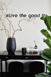 a black table with a vase and a sign on a wall at Luaz Suites in Volos