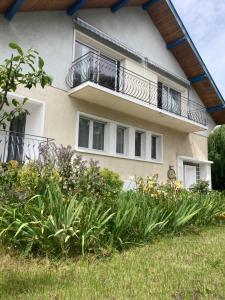 a building with a balcony with plants in front of it at Maison à 2 pas de Genève in Ambilly