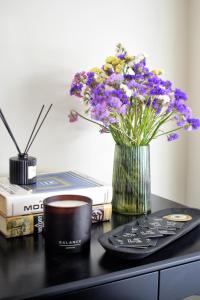 a vase of purple flowers sitting on a desk with books at Luaz Suites in Volos +46 photos