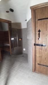uma casa de banho com uma porta de madeira e piso em azulejo em Juula Holiday Home em Juula