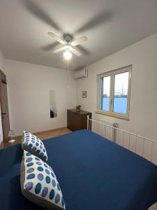 a bedroom with a blue bed with a ceiling fan at Fusella Country House/Villa a Polignano Vista Mare in Polignano a Mare