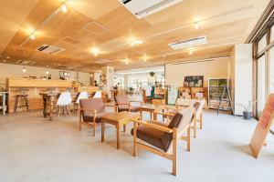 a room with wooden ceilings and tables and chairs at ASA Village in Shirahama