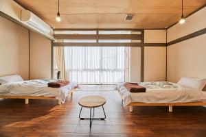 een kamer met twee bedden en een tafel erin bij ASA Village in Shirahama