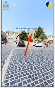 Una flecha naranja apunta a un coche en una calle. en Old City Apartment en Bakú