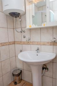 une salle de bain avec un lavabo blanc et un miroir dans l'établissement Palmagora Villas, à Tivat
