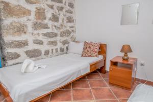 Cette chambre comprend 2 lits et un mur en pierre. dans l'établissement Palmagora Villas, à Tivat 92 autres photos
