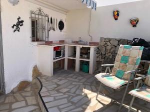 - une cuisine avec un comptoir et des chaises dans la chambre dans l'établissement Casita Mona - Attractive Studio Apartment 4kms from the beach, à Moraira