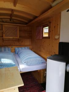 Habitación pequeña con 2 camas en una cabaña en Schlosswirt Chalets & Apartments, en Großkirchheim