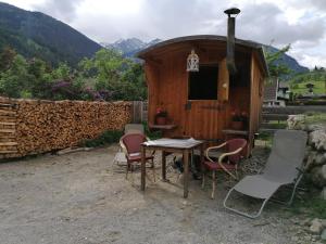 una mesa y sillas frente a un cobertizo en Schlosswirt Chalets & Apartments, en Großkirchheim