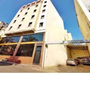 伊斯坦布尔东方敏特尔酒店的一座高大的白色建筑,前面有一辆汽车