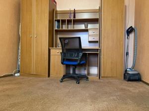 un bureau avec une chaise et un bureau ainsi qu'un aspirateur dans l'établissement Гагарина ДАФФИ, à Dnipro