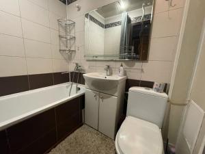 La salle de bains est pourvue de toilettes, d'un lavabo et d'une baignoire. dans l'établissement Гагарина ДАФФИ, à Dnipro