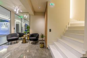 a lobby with chairs and stairs in a store at Luaz Suites in Volos