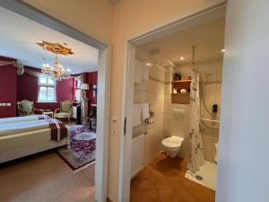 a bedroom with a bed and a bathroom at Hotel & Café Schachtenburg in Schlitz +81 photos