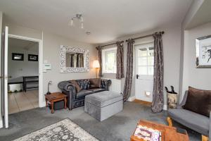 a living room with a couch and a chair at Stable Cottage in Ilminster