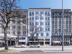 a large white building with cars parked in front of it at Novum Hotel Kronprinz Hamburg Hauptbahnhof in Hamburg