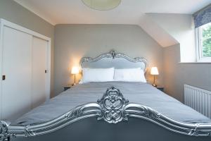 1 cama con marco de plata en un dormitorio en Stable Cottage en Ilminster