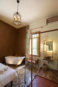 a bathroom with a tub and a bed and a sink at Beit Toureef in Beirut