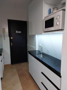 une cuisine avec une porte noire et un four micro-ondes dans l'établissement Appartement entier à une chambre à coucher, à Agadir