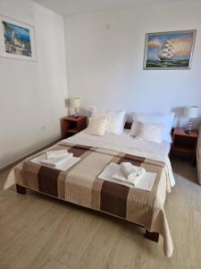 a bedroom with two beds with towels on them at Apartments Šarić in Baška Voda