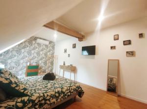 Le domaine du Quercy في باديراك: غرفة نوم مع سرير وتلفزيون على الحائط