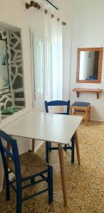 a white table and chairs in a room at Ilias Place in Ios Chora