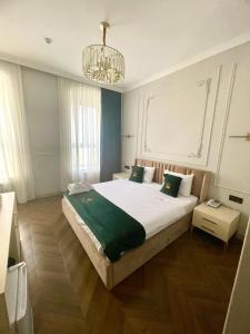 een slaapkamer met een groot bed en een kroonluchter bij Perla De Mar Hotel in Baku