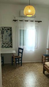a room with a table and a chair and a window at Ilias Place in Ios Chora