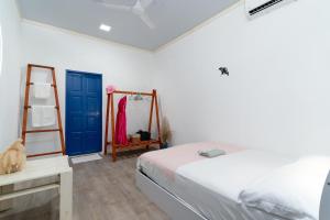 una camera con un letto e una porta blu di Villa Boheme a Ukulhas