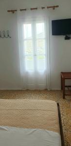 a bedroom with a bed and a large window at Ilias Place in Ios Chora