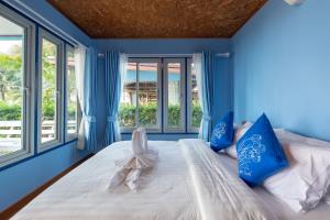 a blue bedroom with a bed with blue walls and windows at Seafar Resort in Ko Kood +113 photos