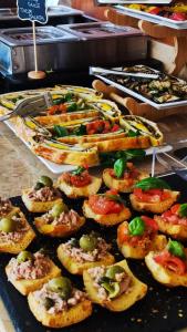 a bunch of appetizers on a buffet table withiov at Hotel Virginia in Garda