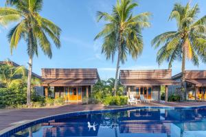 a villa with a swimming pool and palm trees at Seafar Resort in Ko Kood