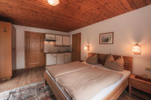 1 dormitorio con 1 cama grande y cocina en Pension Andrea, en Fusch an der Glocknerstrasse