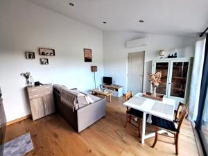 Gîte de charme SPA privatif في مالوسان: غرفة معيشة مع أريكة وطاولة