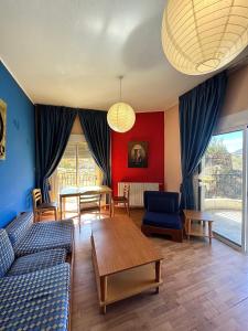 a living room with a blue couch and a table at Olympia in Kfardebian