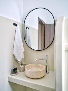a bathroom with a sink with a large mirror at Paridian Elegant Living in Kampos Paros