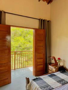 a bedroom with a door open to a balcony at Reserva do Bosque Hospedaria e Natureza in Ibicoara