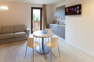a kitchen and a living room with a table and chairs at Residence Lenno in Lenno