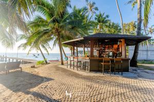 a bar on the beach with palm trees and the ocean at Seafar Resort in Ko Kood
