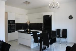 uma cozinha com cadeiras pretas e uma mesa preta em BLACK & WHITE SeaSide House Kalamia em Corinto
