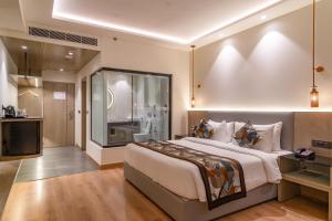 una camera con un grande letto e una televisione di Regenta Place Amritsar by Royal Orchid Hotels Limited ad Amritsar