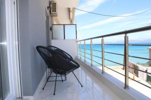 uma varanda com duas cadeiras e o oceano em BLACK & WHITE SeaSide House Kalamia em Corinto