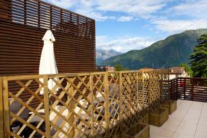 a balcony with a white umbrella and mountains at Residence Lenno in Lenno