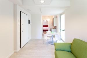 a living room with a green couch and a table at Residence Lenno in Lenno