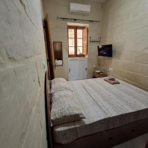 ein Schlafzimmer mit einem Bett und einem TV in der Unterkunft Three Apartment in Vittoriosa