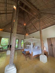 a bedroom with a bed and a large ceiling at Thani Villa Ubud in Ubud +62 photos
